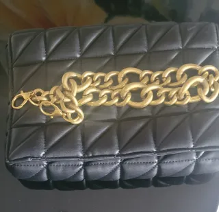 Bolso negro acolchado con cadena dorada