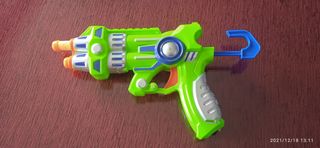 Pistola de juguete verde con dos dardos