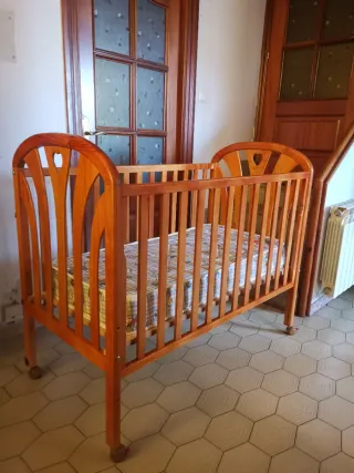 Cuna de madera con colchón y ropa