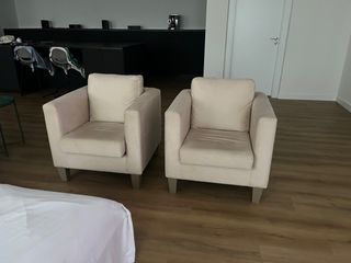 Sofá individual beige de tela.