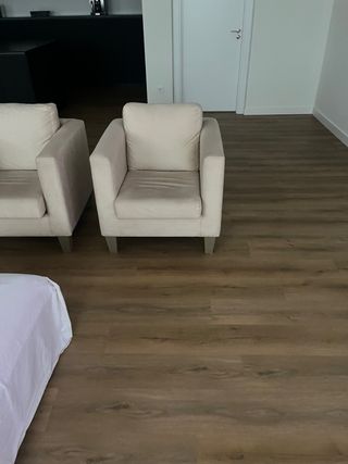 Sofá individual beige de tela.