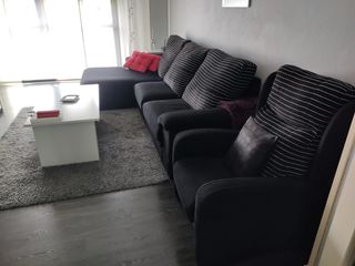 Sofá modular negro con chaiselongue y sillón