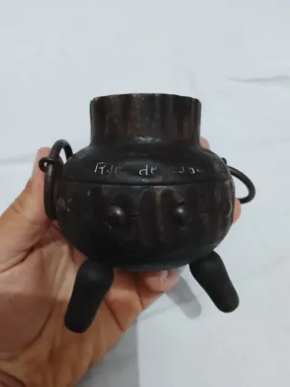 Olla antigua de metal con asas y patas