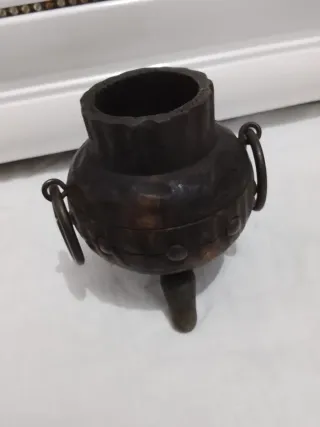 Olla antigua de metal con asas y patas