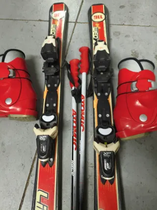 Botas, esquís y bastones de esquí rojos
