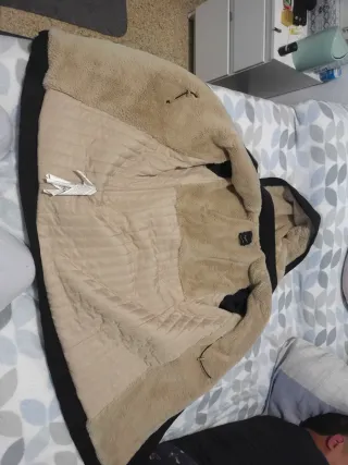 Abrigo negro con capucha y cremalleras doradas