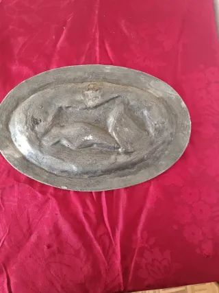 Peça decorativa antiga em metal com cena de caça