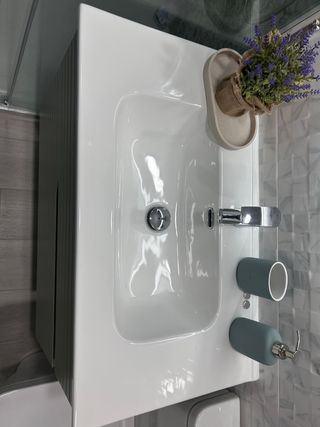Mueble de baño verde con lavabo blanco