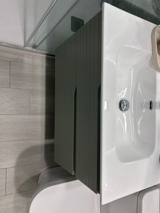 Mueble de baño verde con lavabo blanco