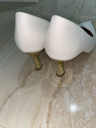Tacones blancos elegantes con tacón dorado