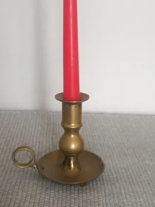 Castiçal antigo de bronze com vela vermelha