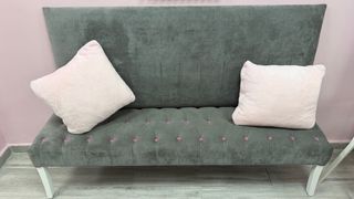 Sofá de terciopelo gris con detalles rosas