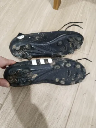 Botas de fútbol negras con detalles blancos