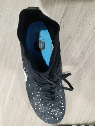 Botas de fútbol negras con detalles blancos