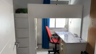 Cama alta con escritorio y armario.