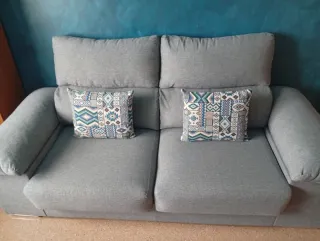Sofá de tela gris con cojines