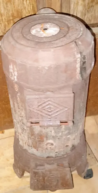 Estufa de leña antigua funcionando o decorativa.