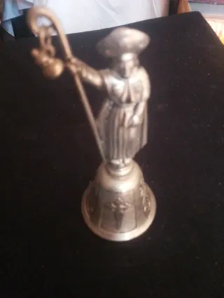 Campana de metal con figura