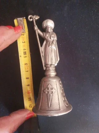Campana de metal con figura