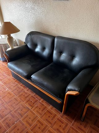 Sofá de piel negro con detalles en madera