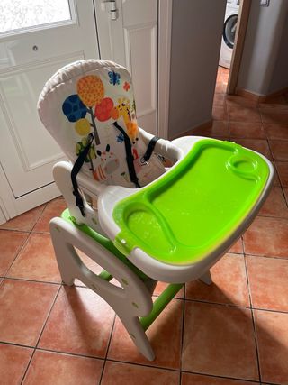 Trona de bebé con mesa y cojín.