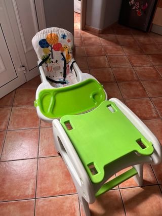 Trona de bebé con mesa y cojín.