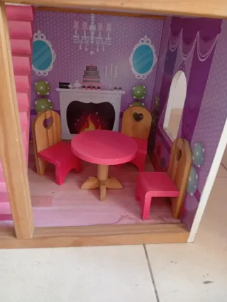 Casa de muñecas de madera rosa.