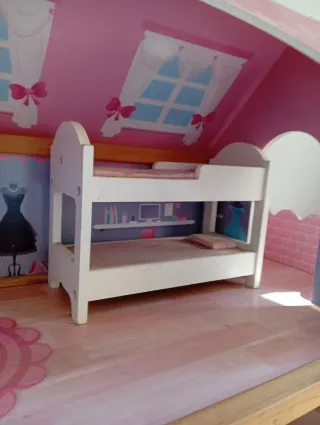 Casa de muñecas de madera rosa.