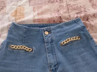 Pantalón vaquero azul con cadena dorada
