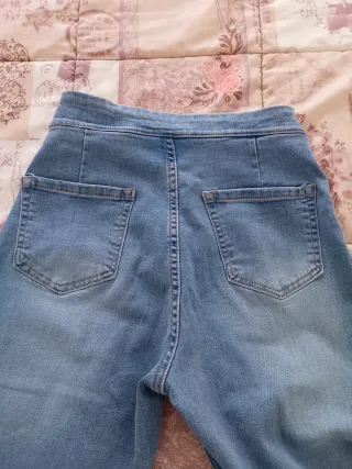 Pantalón vaquero azul con cadena dorada