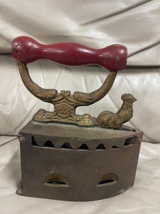 Plancha antigua de carbón en hierro con mango rojo