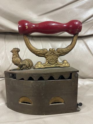 Plancha antigua de carbón en hierro con mango rojo