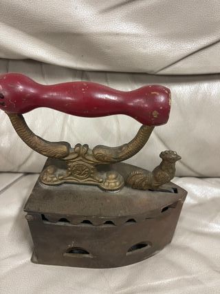 Plancha antigua de carbón en hierro con mango rojo