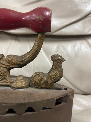 Plancha antigua de carbón en hierro con mango rojo