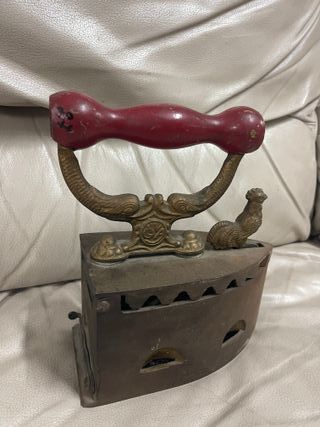 Plancha antigua de carbón en hierro con mango rojo