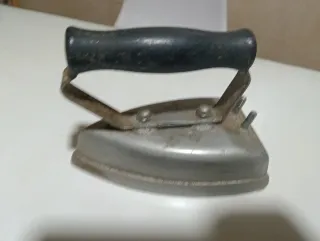 Plancha antigua de metal con mango de madera