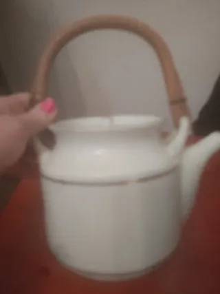 Preciosa tetera de porcelana con bordes dorados