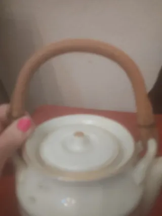 Preciosa tetera de porcelana con bordes dorados