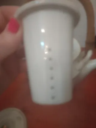 Preciosa tetera de porcelana con bordes dorados