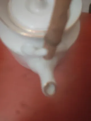 Preciosa tetera de porcelana con bordes dorados