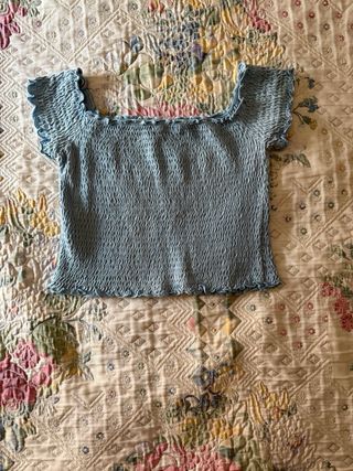 Crop top arrugado azul sin hombros.