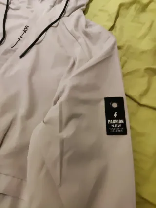 Cortavientos con capucha y bolsillos . Talla XL