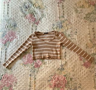 Jersey marrón cropped con rayas blancas.