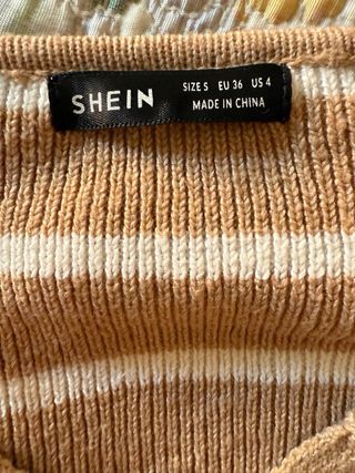 Jersey marrón cropped con rayas blancas.