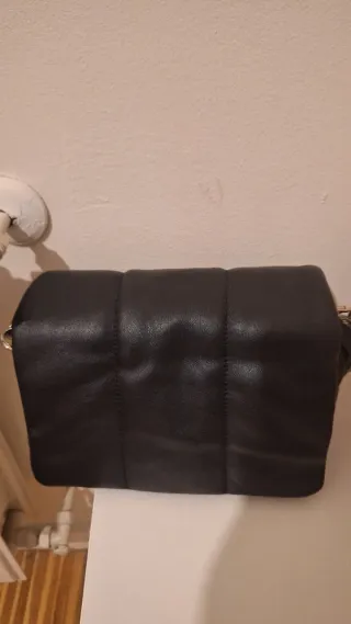 Bolso negro acolchado.