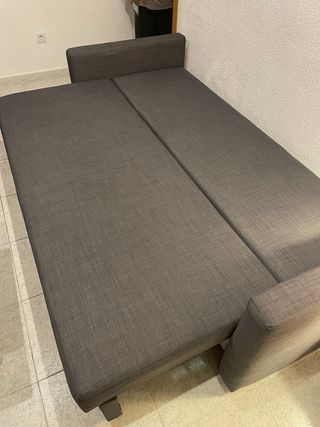 Sofá-cama amplio y cómodo en color gris oscuro.