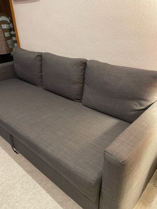 Sofá-cama amplio y cómodo en color gris oscuro.