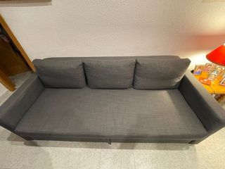 Sofá-cama amplio y cómodo en color gris oscuro.