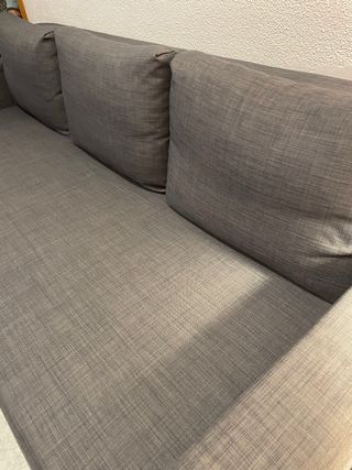 Sofá-cama amplio y cómodo en color gris oscuro.