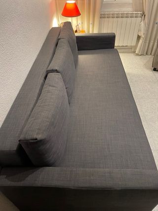 Sofá-cama amplio y cómodo en color gris oscuro.